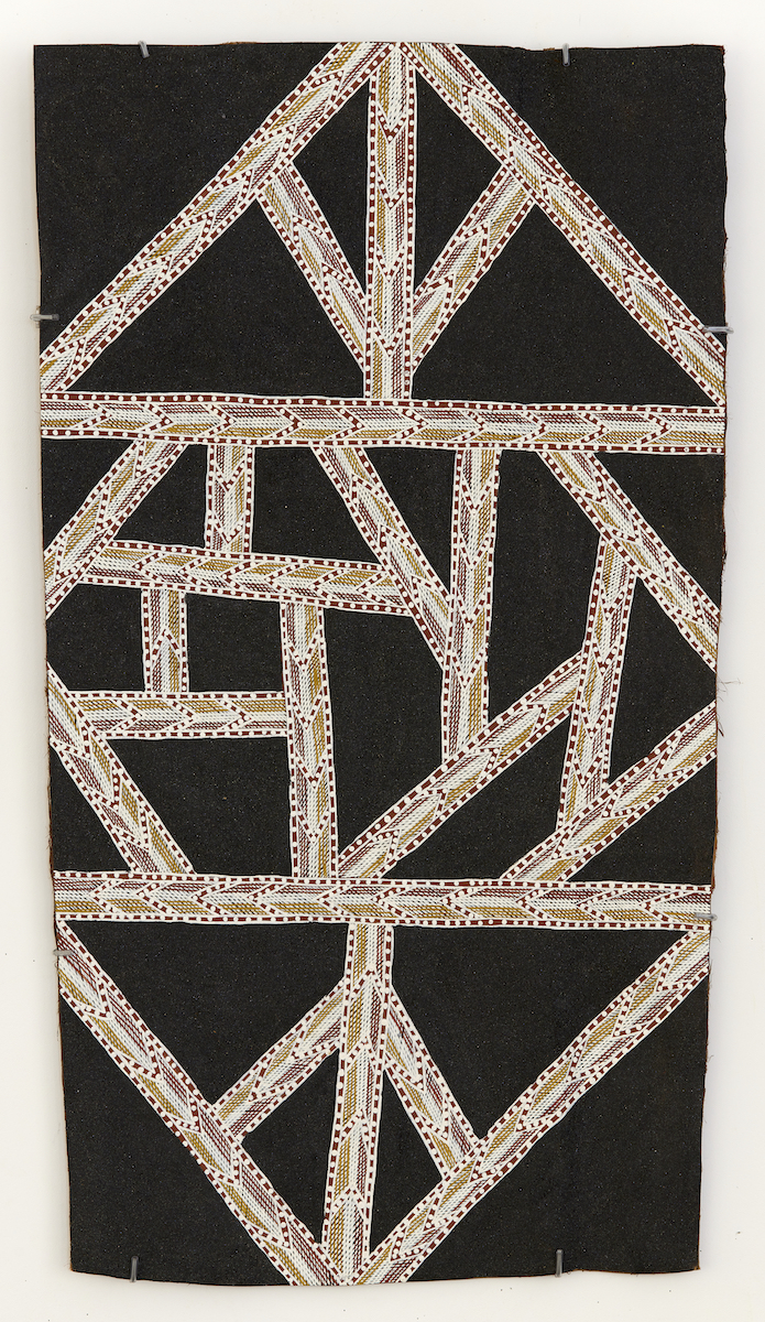 Abstract painting on bark with a shimmering black sand background overlaid with geometric triangular lines composed of yellow, red and white patterning.