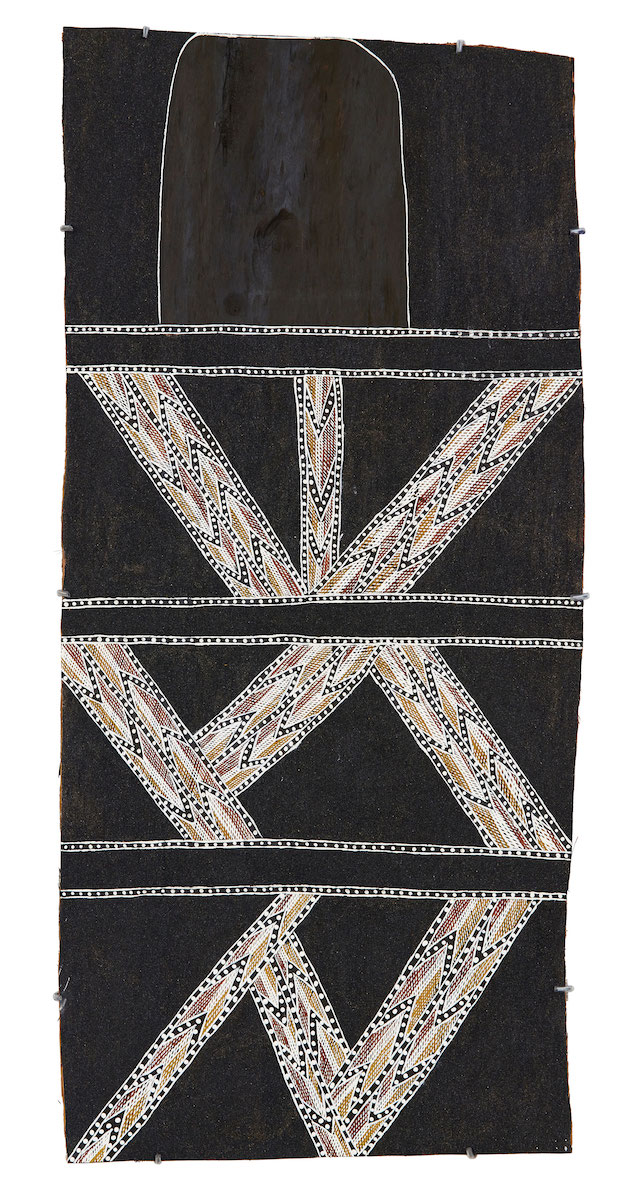 Abstract painting on bark with a shimmering black sand background overlaid with a black section at the top and geometric triangular lines composed of yellow, red and white patterning below.