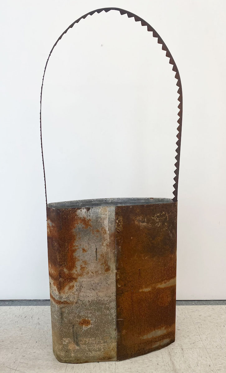 A large rusted metal bag-shaped sculpture