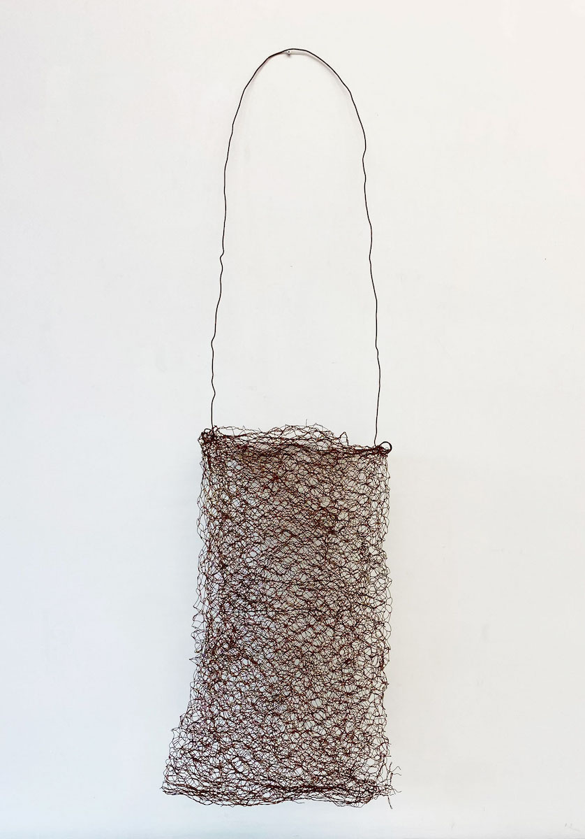 A large bag-shaped sculpture made of burnt fencing wire