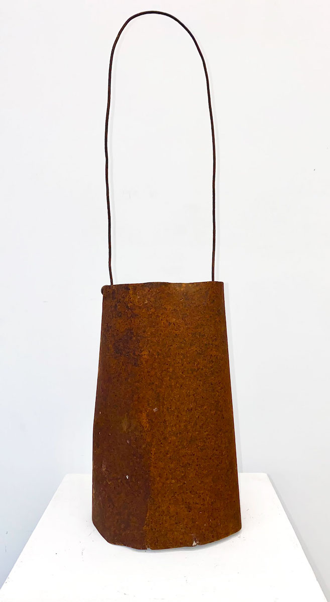 A bag-shaped sculpture made of rusted tin