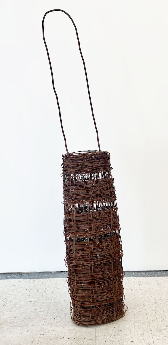 A large bag-shaped sculpture made of rusted wire