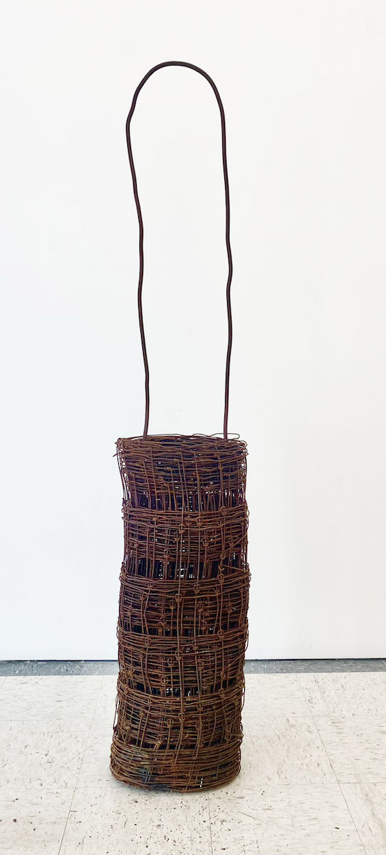 A large bag-shaped sculpture made of rusted wire