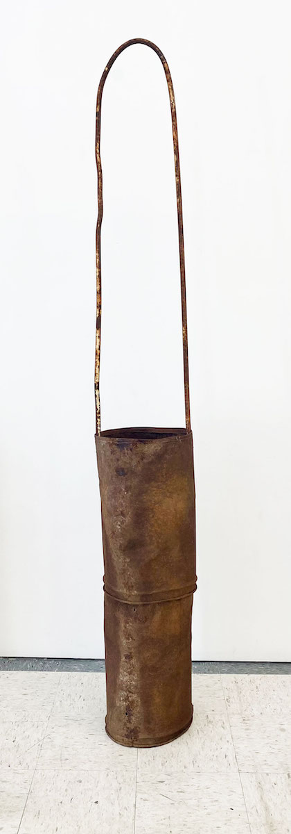 A large bag-shaped sculpture made of rusted steel and corrugated iron