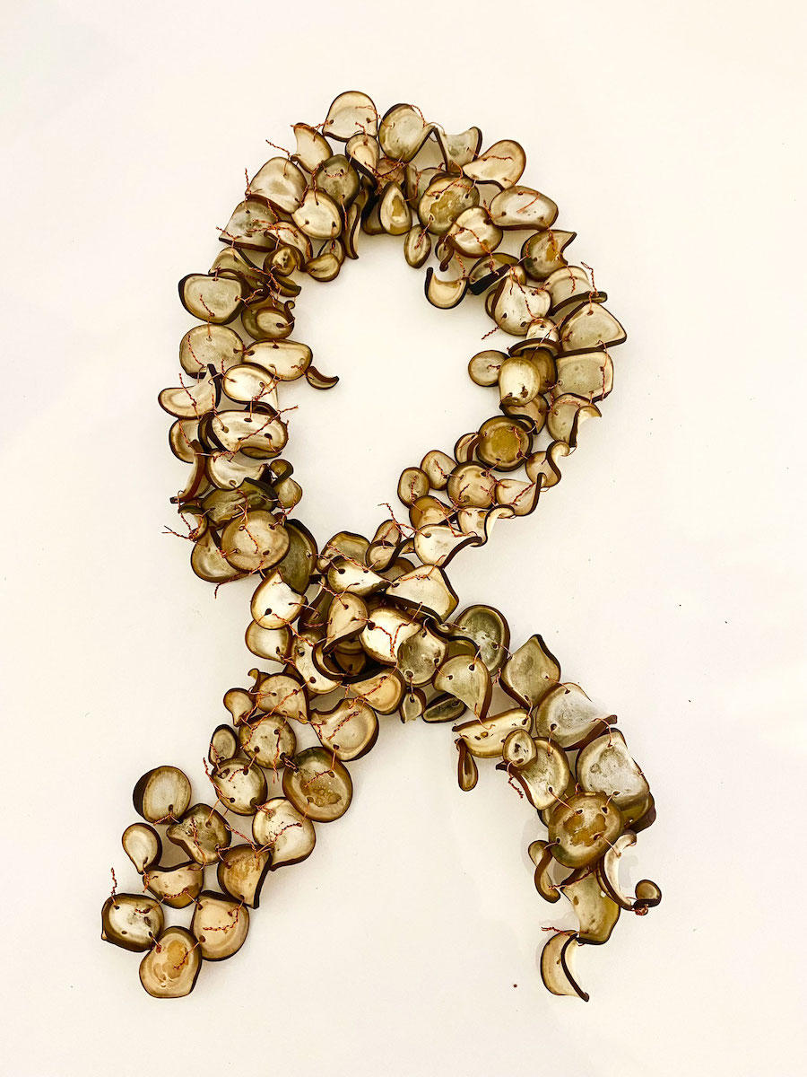 An open-ended necklace made from dried kelp stalks